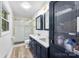 Modern bathroom featuring dual sinks, a glass shower, and chic blue cabinetry with gold hardware at 1822 N New Hope Rd, Gastonia, NC 28054