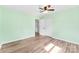 Bedroom with light green walls, wood-look floors, ceiling fan, closet, and natural light from windows at 1822 N New Hope Rd, Gastonia, NC 28054