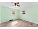 Bedroom with light green walls, wood-look floors, ceiling fan, and natural light from two windows at 1822 N New Hope Rd, Gastonia, NC 28054