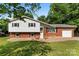 Charming split-level home featuring a brick facade and white siding, complemented by a well-manicured lawn at 1822 N New Hope Rd, Gastonia, NC 28054