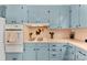 Bright kitchen showcasing blue cabinetry, neutral countertops, and modern cooking appliances at 1822 N New Hope Rd, Gastonia, NC 28054