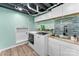 Laundry room with modern appliances, a utility sink, and a mosaic tile backsplash at 1822 N New Hope Rd, Gastonia, NC 28054