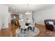 Open-concept dining area with a glass table, modern chandelier, and kitchen view, creating a seamless flow at 18460 W Catawba Ave, Cornelius, NC 28031