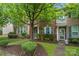 Inviting brick townhome with a landscaped front yard and walkway leading to the entrance at 18460 W Catawba Ave, Cornelius, NC 28031