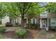 Brick townhouse with a well-landscaped front yard and welcoming entryway, showcasing curb appeal and charm at 18460 W Catawba Ave, Cornelius, NC 28031