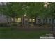 Charming brick townhouse with manicured bushes at dusk, exuding a warm and inviting ambiance at 18460 W Catawba Ave, Cornelius, NC 28031