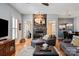 Open concept living room with stone fireplace, hardwood flooring, and views to the dining area and kitchen at 189 Mills Ln, Fort Mill, SC 29708