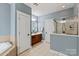 Bright main bathroom with tiled floors, walk-in shower, vanity with storage, and a soaking tub at 189 Mills Ln, Fort Mill, SC 29708