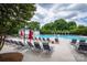 Community pool with plenty of lounge chairs, umbrellas, and a clubhouse in the background at 189 Mills Ln, Fort Mill, SC 29708