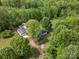 Aerial view of wooded property with a house, two outbuildings, and a long driveway at 195 Bluebird Ln, Salisbury, NC 28146