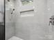 This updated shower features marble floors, built-in shelving, and modern fixtures at 195 Bluebird Ln, Salisbury, NC 28146