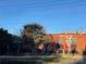 Red brick building with vintage industrial charm, featuring outdoor seating under red umbrellas near railroad at 19812 Elise Caroline Aly, Davidson, NC 28036