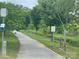 Well maintained walking trail surrounded by lush green trees and vegetation on a sunny day at 19812 Elise Caroline Aly, Davidson, NC 28036