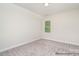 Bright bedroom featuring neutral carpet, fresh paint and natural light from the large window at 20396 Queens St, Cornelius, NC 28031