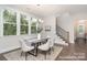 Dining area with large windows offering views, modern chandelier, and staircase access at 20396 Queens St, Cornelius, NC 28031