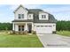 Charming two-story home featuring a two-car garage, landscaped front yard and shingle and board and batten siding at 20396 Queens St, Cornelius, NC 28031