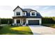 Charming two-story home boasts a manicured lawn, a dark gray garage door, and tasteful exterior accents at 20396 Queens St, Cornelius, NC 28031