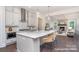 Open-concept kitchen featuring a large island with seating, pendant lights, gray cabinetry, and stainless steel appliances at 20396 Queens St, Cornelius, NC 28031