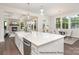 Well-lit kitchen with a large island, stainless steel dishwasher, and access to the dining and living room at 20396 Queens St, Cornelius, NC 28031