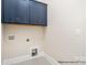 Neat laundry room features plenty of storage cabinets and tiled floor space at 20396 Queens St, Cornelius, NC 28031