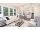 Cozy living room showcases large windows, coffered ceilings, and is open to the kitchen and dining area at 20396 Queens St, Cornelius, NC 28031