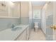 A bright bathroom features blue tiled walls, a white toilet, and a window with natural light at 211 General Stonewall Jackson Dr, Stanley, NC 28164