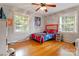 Inviting bedroom featuring hardwood floors, natural light, and sporty decor at 211 General Stonewall Jackson Dr, Stanley, NC 28164