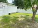 Grassy backyard with a white fence surrounding the property, with tree and shade at 211 Spruce St, Badin, NC 28009
