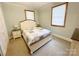 Comfortable bedroom featuring carpet, a bed, two bedside tables, and two windows at 211 Spruce St, Badin, NC 28009