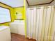 Combined laundry/bath area with washer, dryer, shelves, and shower with striped curtain at 211 Spruce St, Badin, NC 28009