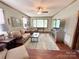 Cozy living room featuring hardwood-look floors, comfortable seating, large windows, and neutral paint at 211 Spruce St, Badin, NC 28009