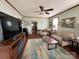 Well-lit living room featuring hardwood-look floors, neutral paint, comfortable seating, and a modern television at 211 Spruce St, Badin, NC 28009