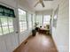 Cozy sunroom with plenty of natural light from the surrounding windows, with indoor plants, and wood floor at 211 Spruce St, Badin, NC 28009