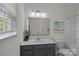 Well-lit bathroom featuring a vanity with grey cabinets and a large mirror at 2185 Loire Valley Dr, Fort Mill, SC 29707