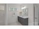 Neutral bathroom with a dark gray vanity, a large mirror, and modern lighting at 2185 Loire Valley Dr, Fort Mill, SC 29707