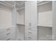 Bright walk-in closet with white built-in shelving, drawers, and ample storage space at 2185 Loire Valley Dr, Fort Mill, SC 29707