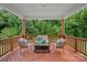 Covered porch with stylish outdoor seating, perfect for enjoying the serene wooded view at 2185 Loire Valley Dr, Fort Mill, SC 29707