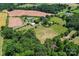Aerial view of land with farm, trees, and multiple outbuildings on a partly cloudy day at 2315 Lanesboro Rd, Marshville, NC 28103