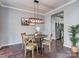 Charming dining area with modern light fixture, hardwood floors, and an adjacent kitchen at 2331 Whitford Ln, Charlotte, NC 28210