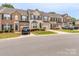 A row of townhomes featuring brick and siding exteriors, dark shutters, and well-maintained landscaping at 2331 Whitford Ln, Charlotte, NC 28210