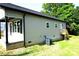 Rear view of the home with a small wooden deck and updated siding at 256 Lincoln Sw St # 1, Concord, NC 28025