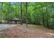 Shot of a detached garage and carport nestled in a serene, wooded area with ample parking space at 3000 Low Gap Rd, Waxhaw, NC 28173