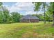 Brick home with a large backyard area bordered by mature trees and a black fence at 3178 Newcastle Dr # 42, Rock Hill, SC 29732