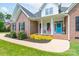 Close-up of the front exterior featuring a brick facade, a bright blue door and rocking chairs on the front porch at 3178 Newcastle Dr # 42, Rock Hill, SC 29732