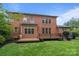 Brick home featuring a wooden deck, manicured lawn, and great natural light at 3206 Lakehurst Xing, Matthews, NC 28104