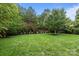 Well-maintained backyard featuring lush green grass, mature trees, and manicured landscaping at 3206 Lakehurst Xing, Matthews, NC 28104
