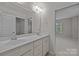 Bright bathroom with double sinks, large mirror, and neutral color scheme, plus view to adjacent bedroom at 3206 Lakehurst Xing, Matthews, NC 28104