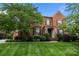 Charming two-story brick home featuring a stone entryway, lush landscaping, and a well-maintained lawn at 3206 Lakehurst Xing, Matthews, NC 28104