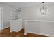 Bright hallway featuring hardwood floors, a modern light fixture, and built-in shelving for storage at 3206 Lakehurst Xing, Matthews, NC 28104