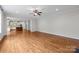 Open living room with hardwood floors and view into the kitchen, providing an ideal space for entertaining at 3206 Lakehurst Xing, Matthews, NC 28104